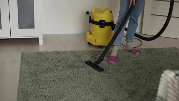 Kadın evde yerleri ve halıları süpürüyor, mikropları temizliyor. - Video, Çekim