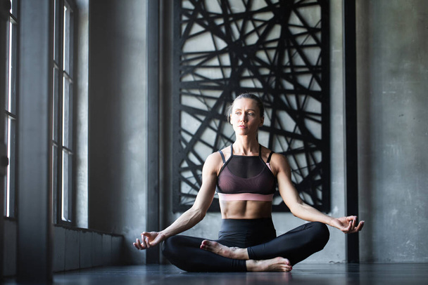 Yoga woman meditating after workout in studio / loft near window. Relax. - Fotografie, Obrázek