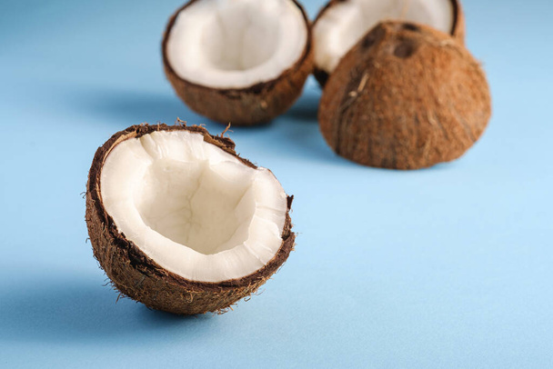 Owoce kokosowe na niebieskim, żywym tle, abstrakcyjna koncepcja tropikalna żywności, makro z widokiem kątowym - Zdjęcie, obraz