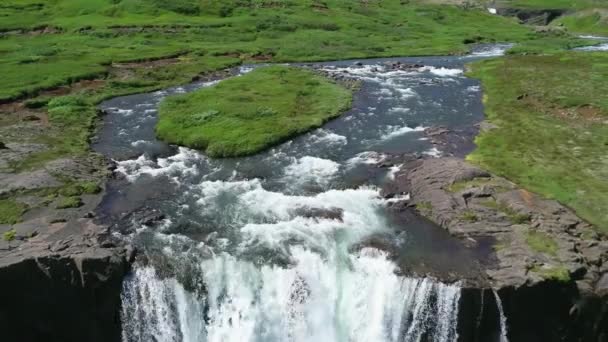 Reverse aerial of a generic waterfall in Iceland falling over steep cliffs. - Felvétel, videó