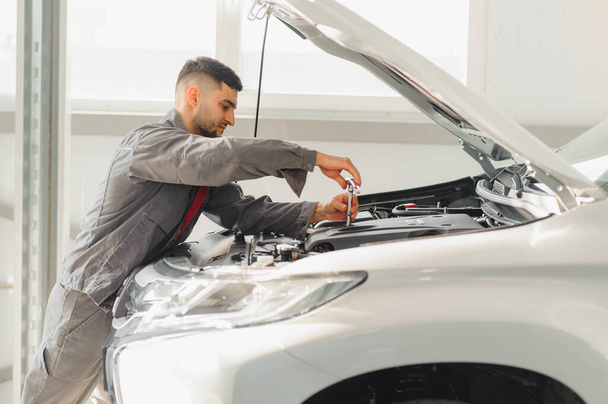 Worker repairs a car in a car repair center - Photo, Image