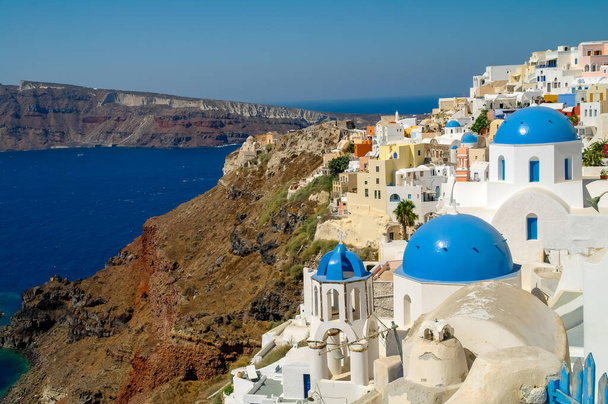 White church with blue dome and Christian cross and seascape in Santorini, officially Thira, an island in the Cyclades, Greece. Image symbolizing holidays, religion and freedom - Zdjęcie, obraz
