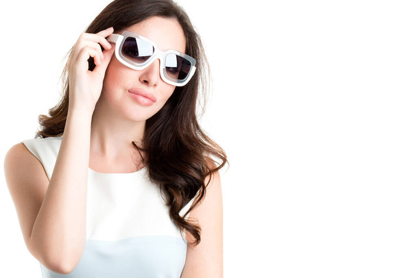 Fashionable portrait of a brunette in sunglasses, isolated. - Foto, imagen