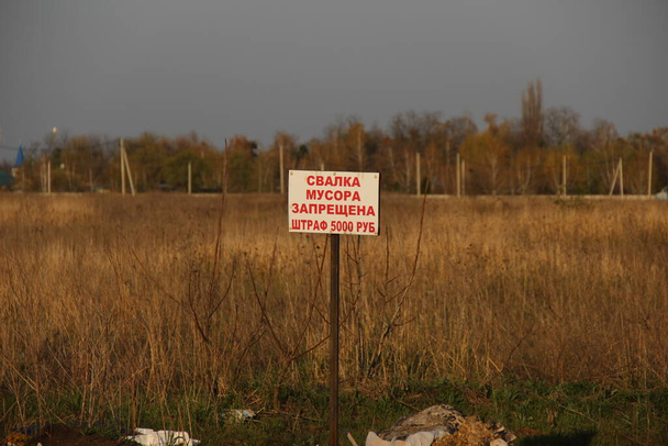 Un cartello sul campo con l'iscrizione in russo "spazzatura discarica è vietata. Una multa di 5.000 rubli
" - Foto, immagini