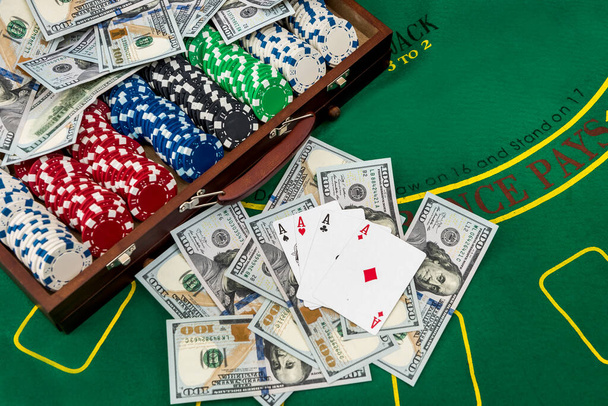 полный ящик фишек для покера с долларами на игровом столе. покер
. - Фото, изображение
