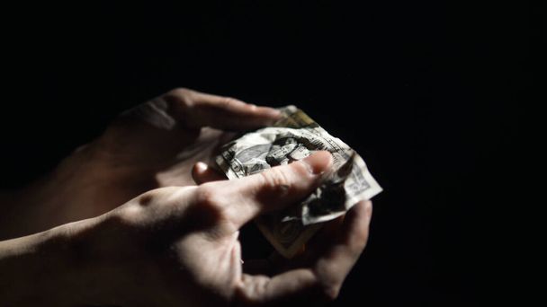 concepto de crisis económica. hombre desenrolla billete de dólar arrugado de trabajador que cayó en manos
 - Foto, Imagen