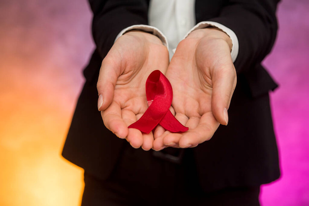 Koncepcja AIDS. Kobieta trzymająca czerwoną wstążkę w dłoniach - Zdjęcie, obraz