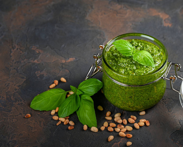 Homemade pesto sauce fresh Basil and nuts on dark background. A copy of the places. Soft focus. - Photo, Image