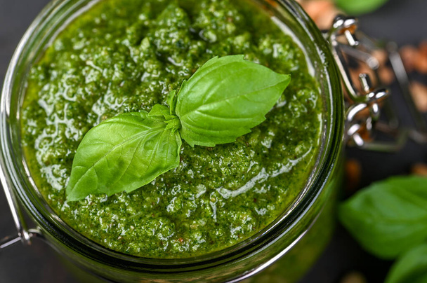 Homemade pesto sauce fresh Basil and nuts on dark background. A copy of the places. Soft focus. - 写真・画像