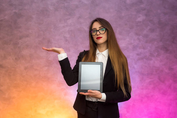 Cute woman in glasses using tablet on abstract background. Business concept - Photo, Image