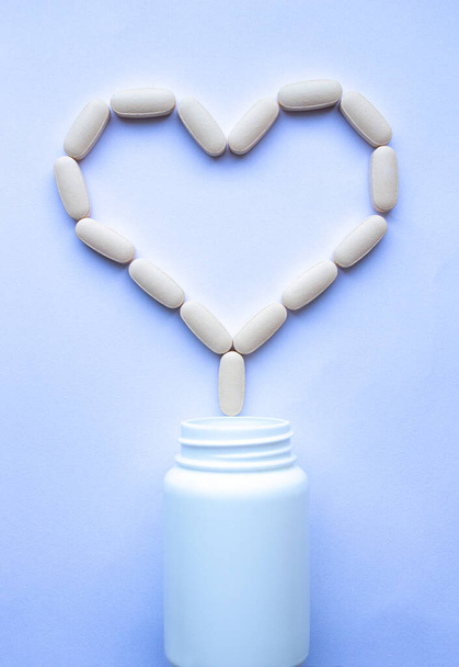 таблетки, наливаються з серцеподібної банки крупним планом
 - Фото, зображення