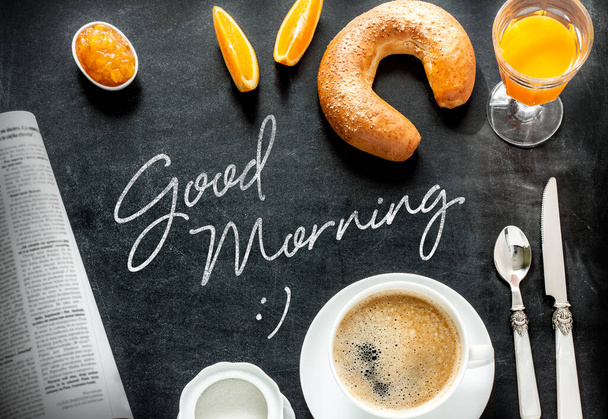 Good morning poster design with continental breakfast on black chalkboard background. Bar morning menu - coffee, orange juice, crescent roll and jam from above (top view, flat lay). - Photo, Image