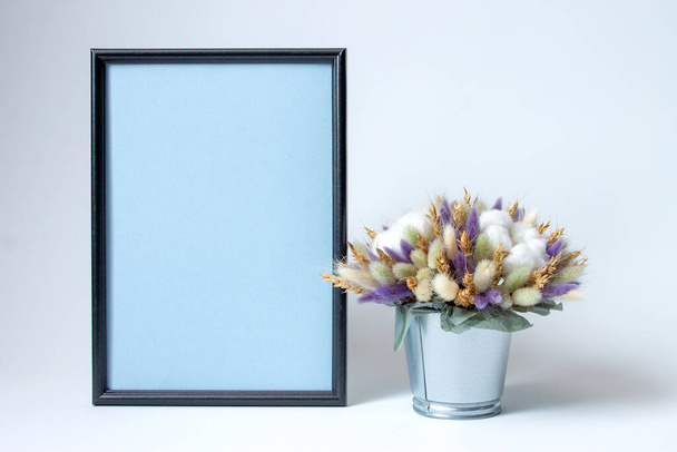 photo frame and decorative arrangement of dried flowers on a white background with copy space - Foto, imagen