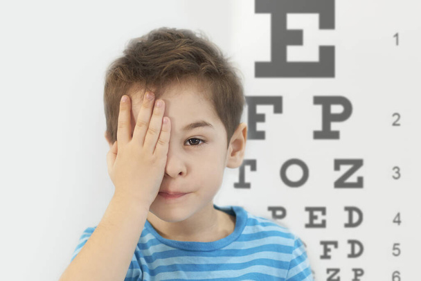 Маленький хлопчик здає аналіз очей в кабінеті офтальмолога
 - Фото, зображення