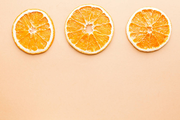  Slice of dried orange on a light background with space for text. Minimalism, food concept. - Foto, Bild