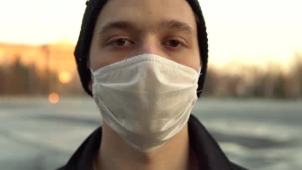 Mladý muž v ochranné masce zblízka, portrét - Záběry, video