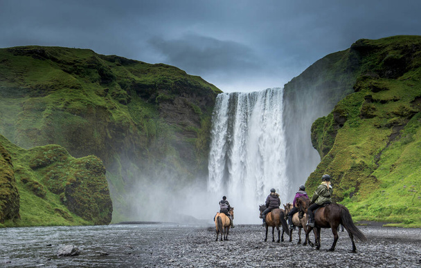アイスランドの夏にあるSkogafoss滝近くの馬ライダー - 写真・画像