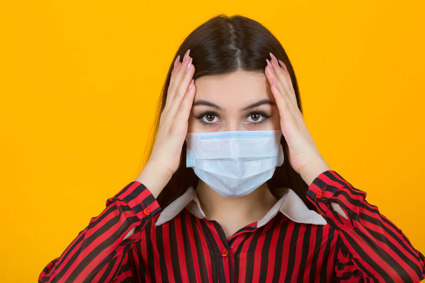 beautiful young woman in medical mask on a yellow background - Fotó, kép