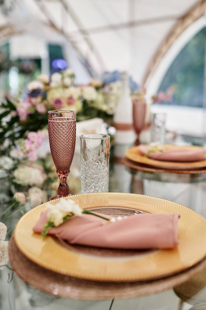 Juego de mesa con flores y cubiertos de oro rosa. De cerca.
 - Foto, Imagen