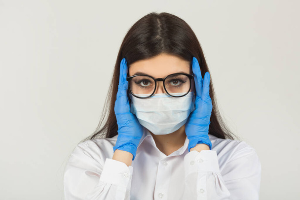 young woman in medical face mask on a white background - Φωτογραφία, εικόνα