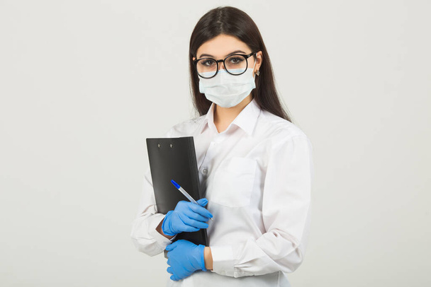 young woman in medical face mask on a white background - Foto, Imagen