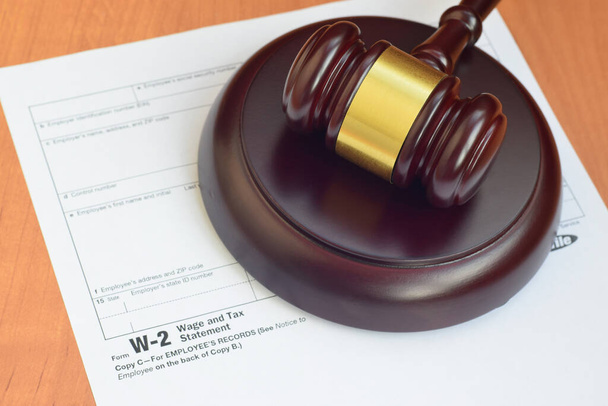 Maletero de la justicia y formulario de declaración de salarios e impuestos W-2 del IRS de cerca
 - Foto, Imagen