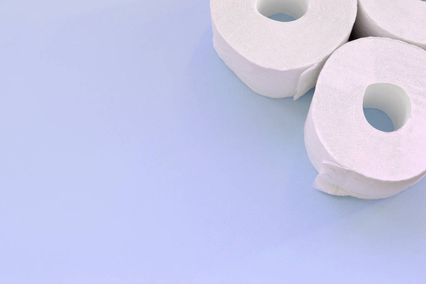 Pandemiczna koncepcja zakupów paniki u koronawirusów. Kilka nowych rolki papieru toaletowego na jasnoniebieskim tle. Minimalistyczna kompozycja płaska z przestrzenią do kopiowania tekstu - Zdjęcie, obraz
