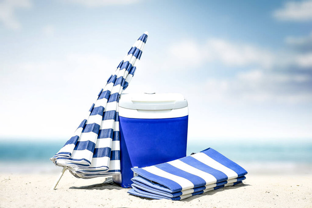 Letnie zdjęcie plaży i niebieskiej plaży lodówka z parasolem. Słoneczny dzień i krajobraz oceanu.  - Zdjęcie, obraz