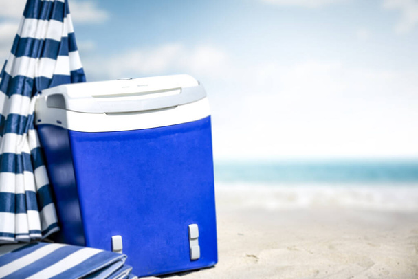 Summer photo of beach and blue beach fridge with umbrella. Sunny day and ocean landscape.  - Zdjęcie, obraz