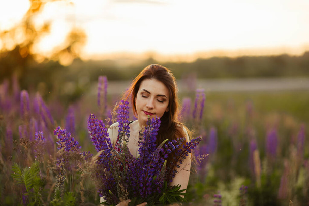 happy young girl smiling, holding hands in lavender. Soft focus, close-up. - Fotó, kép