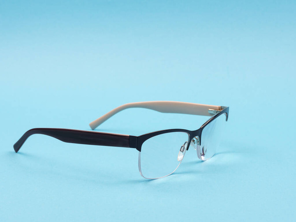 Brille zur Verbesserung des Sehvermögens auf blauem Hintergrund. - Foto, Bild