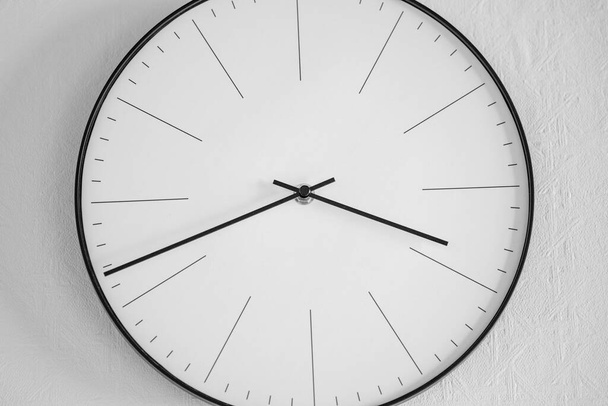 Gros plan d'une horloge blanche et noire sur un mur blanc - le concept du temps
 - Photo, image