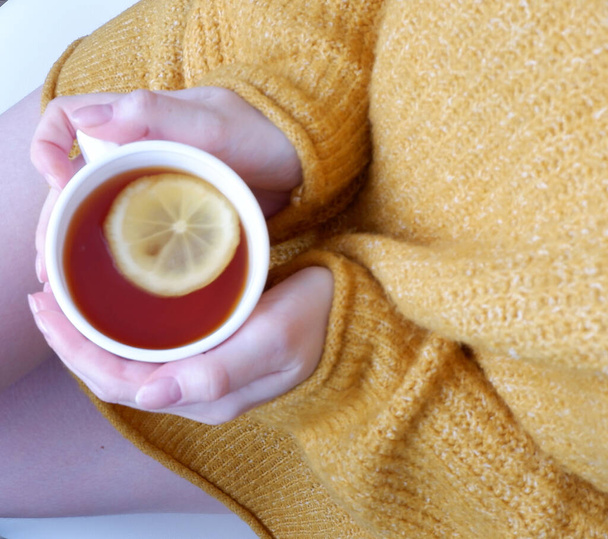 hands with a Cup of tea with lemon, on a beautiful background. Mockup. Vitamins - Foto, immagini