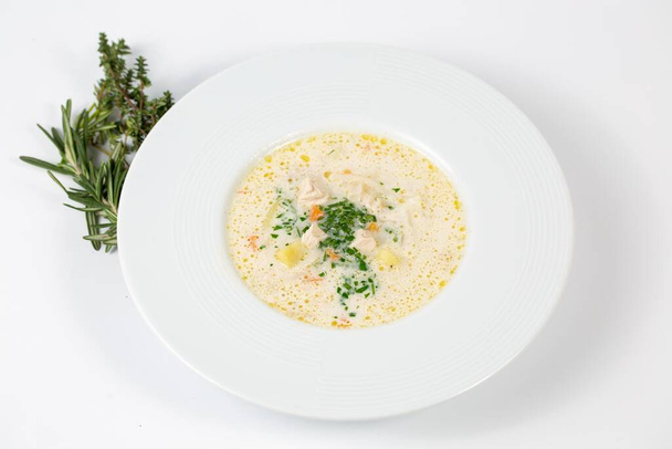 A closeup shot of a plate with white soup with greens - Foto, Bild