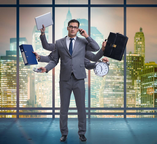 Young businessman in multitasking concept - Photo, Image