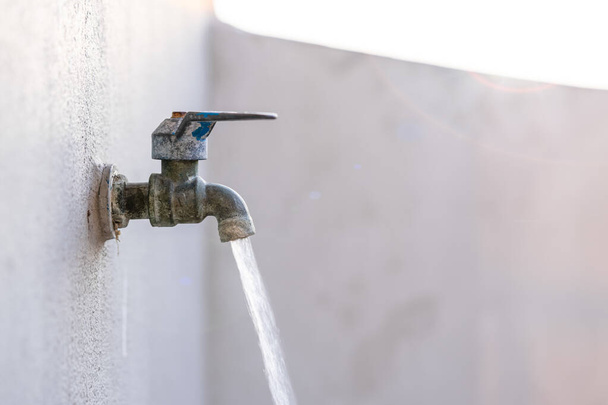 Vecchio rubinetto che sta aprendo e acqua corrente, concetti di risparmio idrico
 - Foto, immagini