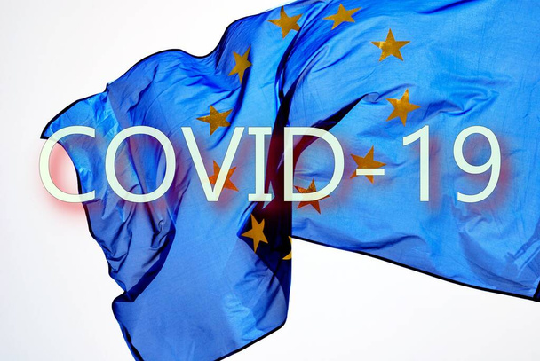 Σημαία της Ευρώπης στον άνεμο με κείμενο COVID 19. - Φωτογραφία, εικόνα