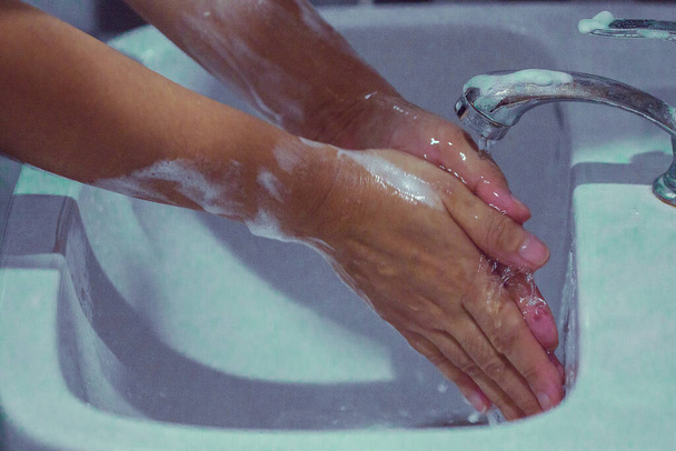 手を石鹸で洗ってコビト19を防ぎ、流行を防ぐために手を洗う. - 写真・画像