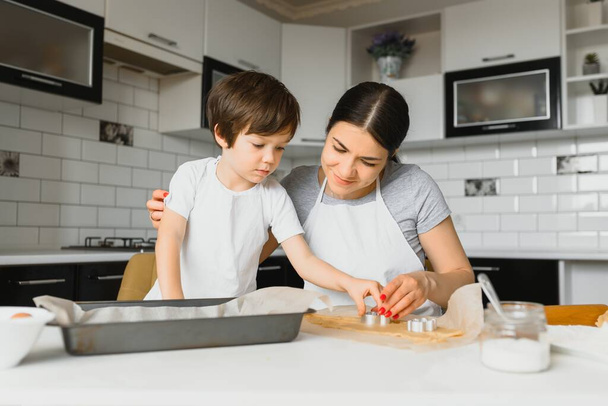 Happy family in the kitchen. Mother and son preparing cookies. - Foto, imagen
