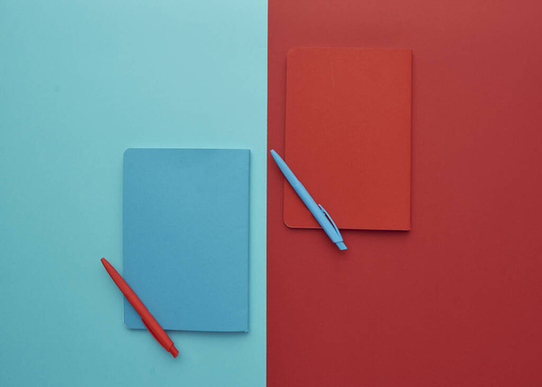 cuaderno sobre un fondo azul y rojo, de vuelta a la escuela, accesorios para estudiantes, espacio libre para una inscripción, puesto plano
 - Foto, imagen