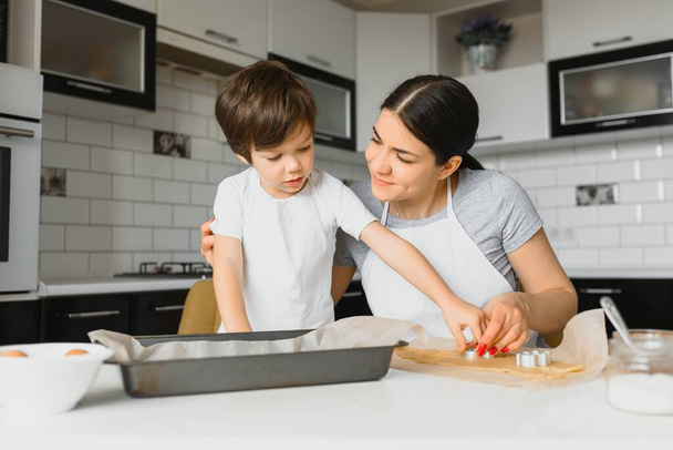 Χαρούμενη μητέρα και ο μικρός γιος στην κουζίνα, ευτυχισμένες στιγμές και συντροφικότητα - Φωτογραφία, εικόνα