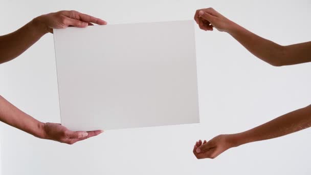 Δύο χέρια πρόσωπο κρατώντας κενό κενό σημάδι λευκό πίνακα για διαφημιστικό περιεχόμενο. Αντιγραφή χώρου διαφήμισης mock up - Πλάνα, βίντεο