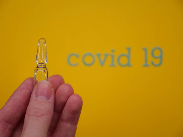 Coronavirus Covid19. Ampolla sobre fondo amarillo
 - Foto, imagen