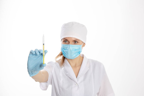 Médico con un abrigo blanco sosteniendo una jeringa
 - Foto, Imagen