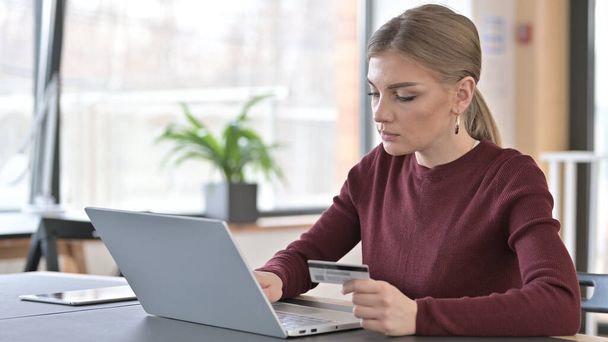 Junge Frau beschäftigt sich mit Online-Shopping am Laptop - Foto, Bild