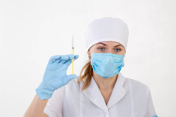 Orvos fehér köpenyben, kezében egy fecskendővel - Fotó, kép