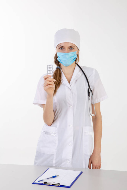 El médico con una bata blanca sostiene una ampolla con pastillas
 - Foto, Imagen