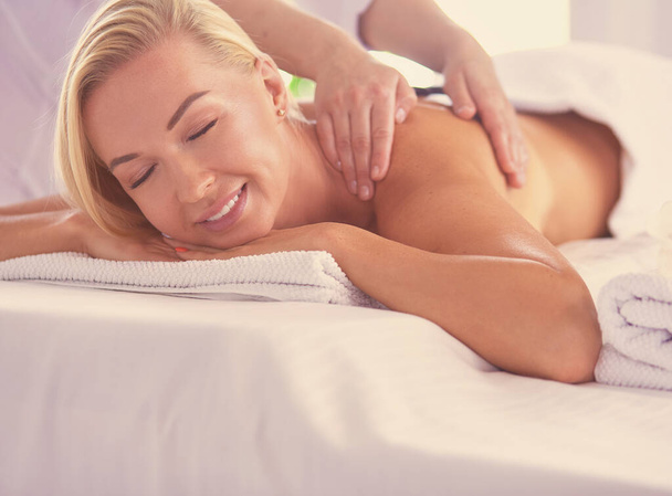 Young woman enjoying massage in spa salon - Foto, Bild