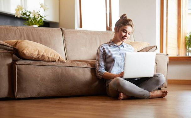 Happy woman with laptop on living room floor - Фото, изображение