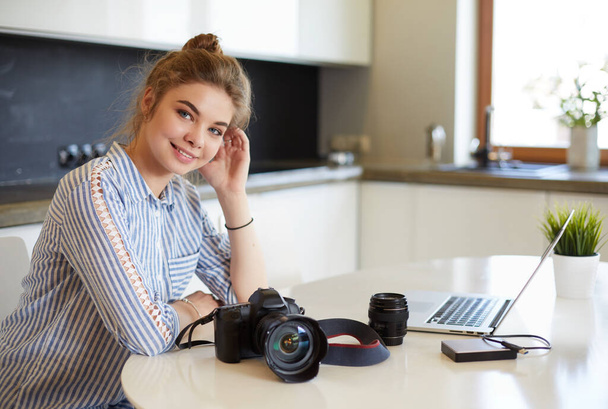 Female photographer sitting on the desk with laptop - Fotó, kép
